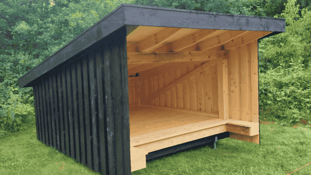 Black-painted shelter on green lawn